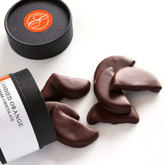 Candied Orange in Dark Chocolate Spilling from Box Angled